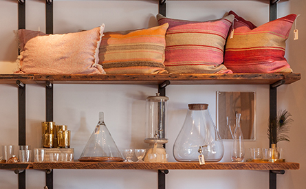 Pillows and various glass bottles on two shelves